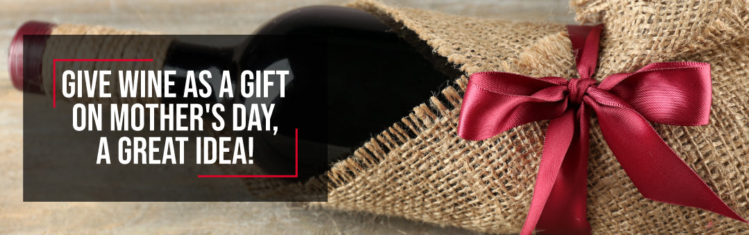 Bottle of red wine wrapped in burlap with a red satin bow, with the title Give wine as a gift on Mother's Day, a great idea