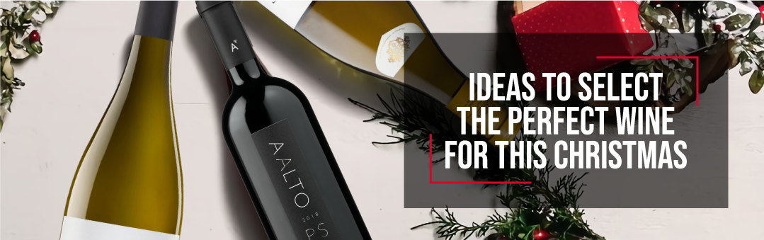 Bottles of white and red wine laid on a pale surface with Christmas greenery and a gift box, with the title Ideas to select the perfect wine for this Christmas
